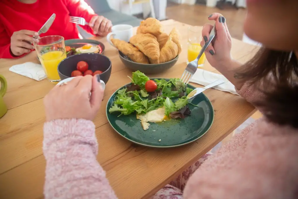 People eating salad and healthy lunch at a table