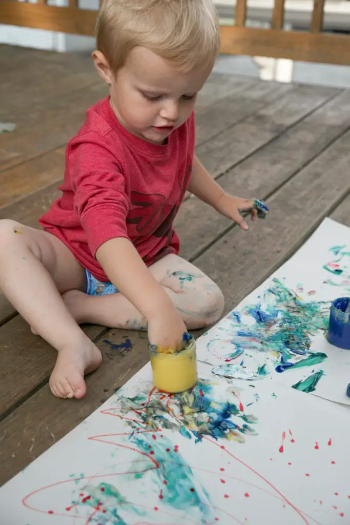 baby doing finger painting
