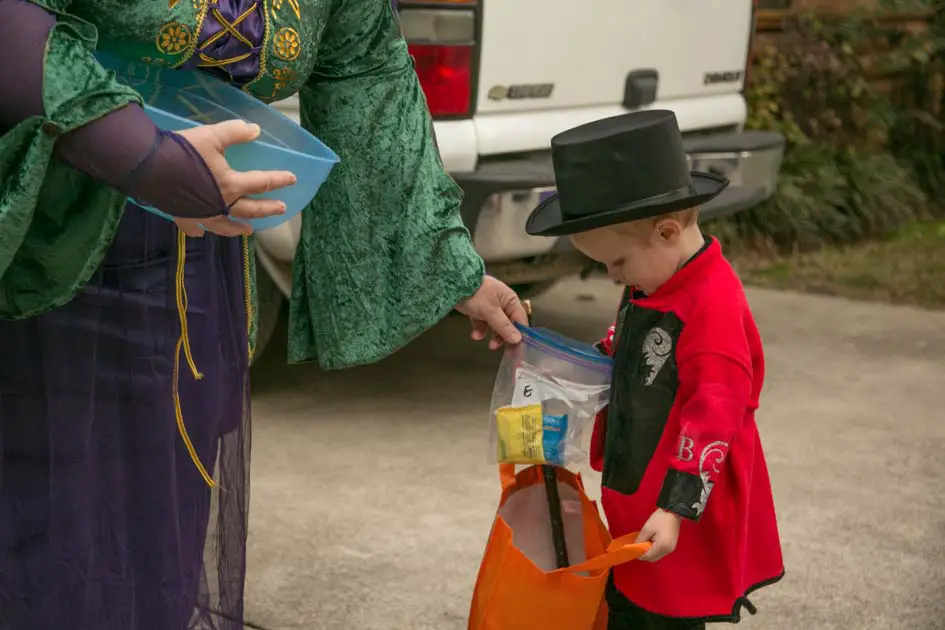 Pre-labaled candy bag being handed to trick or treater with allergies