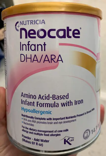 Gold, white, and pink can of neocate infant formula