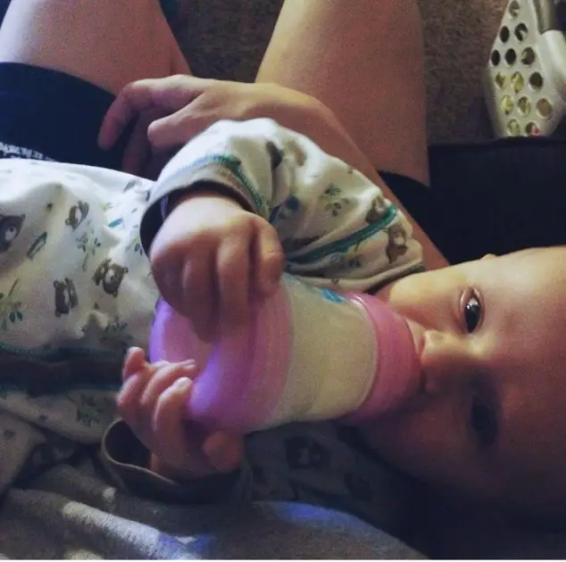 Baby drinking prescription formula out of a bottle