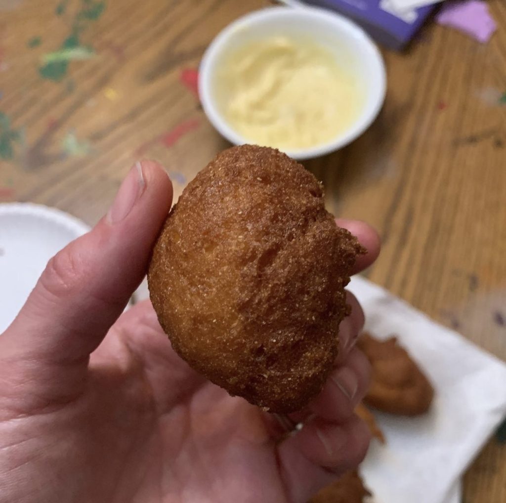 hand holding a gluten free hushpuppy